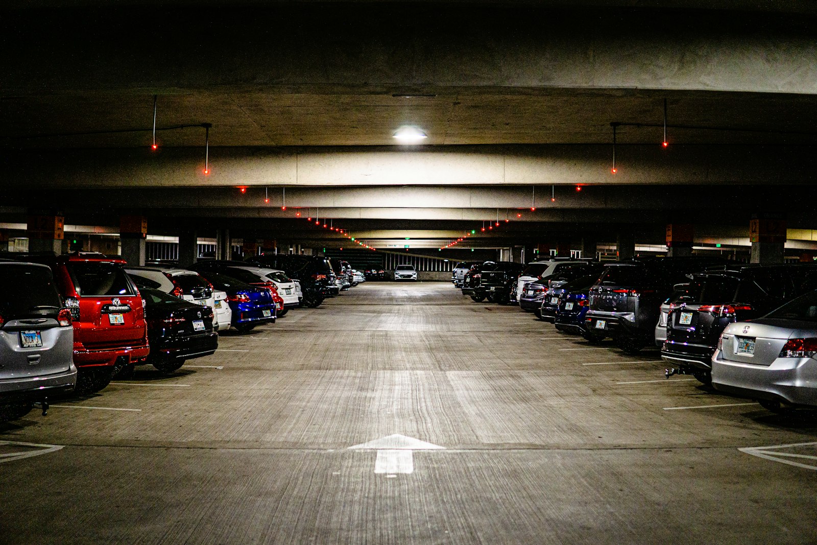 Rows of cars parked in a covered parking structure.