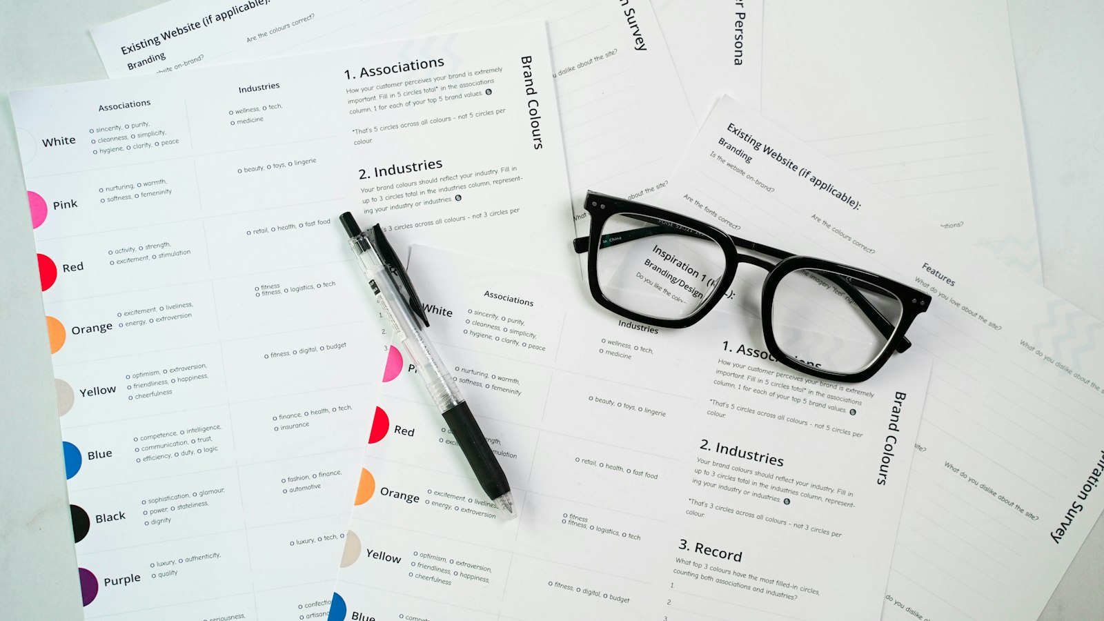 A printed insurance policy lying open on a wooden desk beside reading glasses and a notepad.