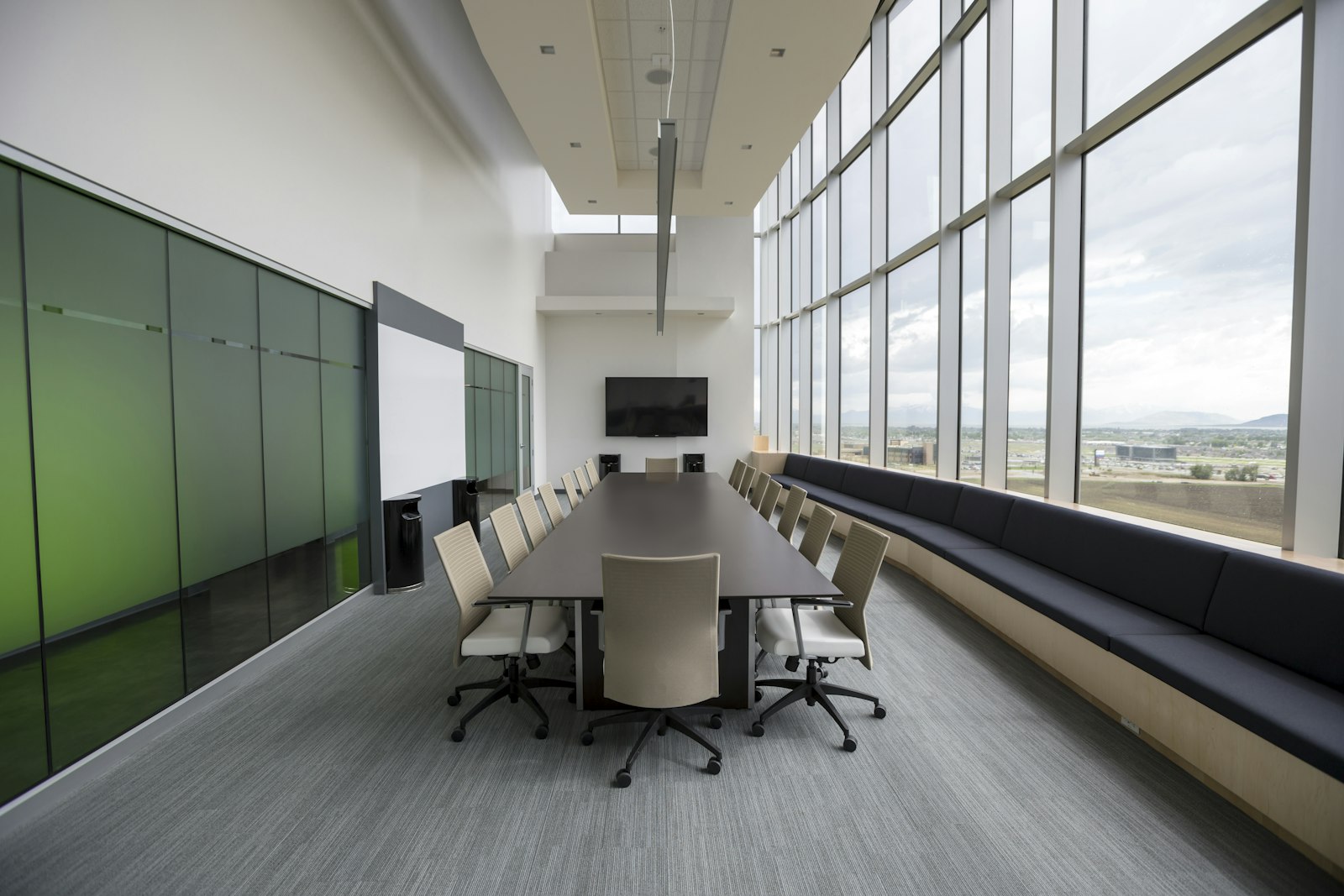 An empty law office conference room with a long wooden table, chairs, and shelves of case binders along the wall.